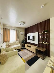 a living room with a couch and a tv at Camella Soleia Manors in Butuan