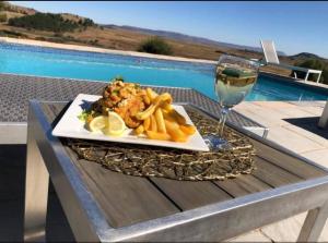 un plato de comida y una copa de vino en una mesa en Grace Lodging and Conference Centre, en Maseru