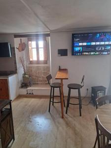 a room with two chairs and a table and a tv at Casa del Convento I- Apartamento rural - in Montán