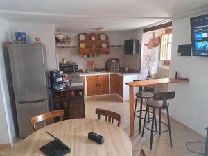 a kitchen with a table and a refrigerator at Casa del Convento I- Apartamento rural - in Montán