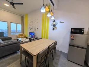 cocina y sala de estar con mesa y nevera en Simfoni Comfy Premium 09, en Kuah