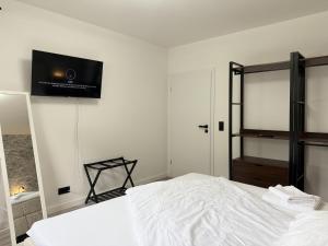 a bedroom with a bed and a flat screen tv on the wall at Oslo: Messe-/Business-/Ferienwohnung in Leichlingen