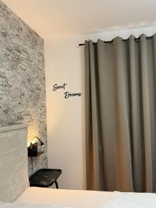 a bedroom with a curtain with the words sweet damage on the wall at Oslo: Messe-/Business-/Ferienwohnung in Leichlingen