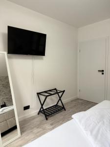 a bedroom with a bed and a television on a wall at Oslo: Messe-/Business-/Ferienwohnung in Leichlingen