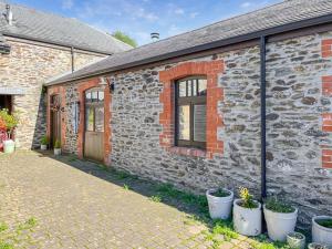 a brick building with potted plants in front of it at The Granary House - Long Stayz in Plymouth