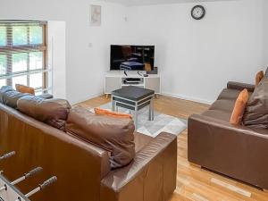 a living room with a leather couch and a table at The Granary House - Long Stayz in Plymouth