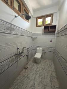 a bathroom with a toilet and a window at The Family Haven Homestay in Golāghāt