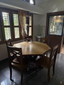 a wooden table and chairs in a room at The Family Haven Homestay in Golāghāt