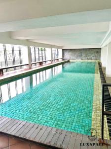 a swimming pool with green tiles in a building at Rex apartment in Gua Sai