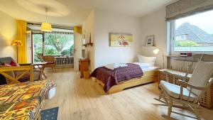 Un dormitorio con una cama y una mesa y sillas. en Feriennest mit Terasse, en Süderende