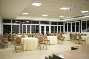 a conference room with tables and chairs and windows at Myspace Hotel JMR in Chitradurga