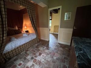 un dormitorio con una cama con una cortina encima en Le Moulin des Marguerites, en Saint-Père