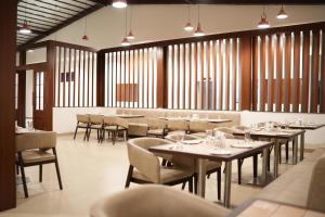 een eetkamer met tafels en stoelen en ramen bij Myspace Hotel JMR in Chitradurga