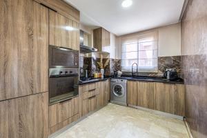 a kitchen with wooden cabinets and a washer and dryer at Prestige 2BR in Marrakech