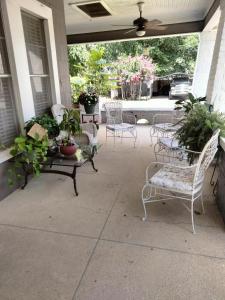 a porch with chairs and potted plants on it at Restful 2 in Ruston