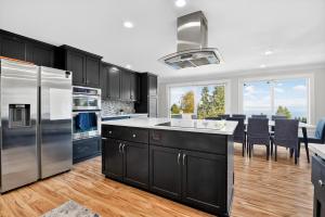 een keuken met zwarte kasten en roestvrijstalen apparatuur bij Oceanline 180° home in Federal Way
