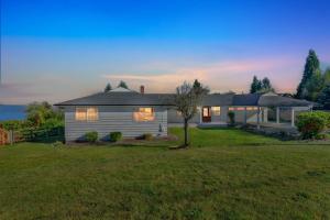 a small white house with a grass yard at Oceanline 180° home in Federal Way