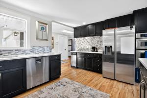 a kitchen with black cabinets and stainless steel appliances at Oceanline 180° home in Federal Way