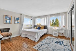 a bedroom with a bed and windows and a desk at Oceanline 180° home in Federal Way