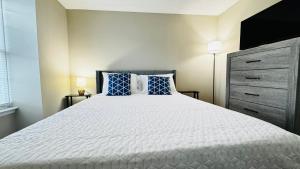 a bedroom with a large bed with blue pillows at Comfort Escape, rooms in Charlotte with shared common spaces in Charlotte