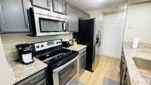 a kitchen with a stove and a microwave at Comfort Escape, rooms in Charlotte with shared common spaces in Charlotte