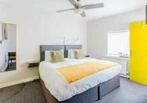 Un dormitorio con una cama grande con una manta amarilla. en Dan Linehan's B&B, en Killarney