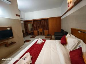 une chambre d'hôtel avec un lit et une télévision à écran plat dans l'établissement Skyry Hotels Gandhipuram, à Coimbatore