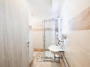 Un baño con lavabo y ducha de cristal. en Hotel Paradise Rooms, en Bitritto 8 fotos más