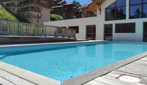 a swimming pool with blue water in a house at Superbe duplex sauna piscine Vars - pied des pistes in Vars
