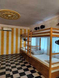 two bunk beds in a room with a checkered floor at Moondance Hostel & Garden Restaurant in Pushkar
