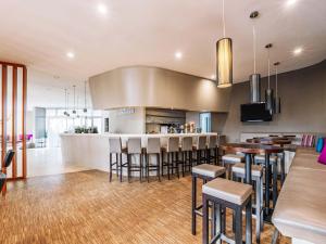 ラシュタットにあるB&B HOTEL Rastattのキッチン(バー、いくつかの椅子とテーブル付)