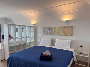 a bedroom with a large bed with a blue blanket at Casa vista Faraglioni Capri 2 in Capri