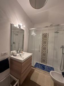 a white bathroom with a shower and a sink at Casa vista Faraglioni Capri 2 in Capri