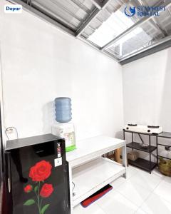 a room with a refrigerator with a flower painted on it at House Rental Gajahmada Residence Mataram Lombok in Prampuan