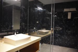 ein Badezimmer mit Waschbecken und Glasdusche in der Unterkunft Myspace Hotel JMR in Chitradurga + 53 Fotos