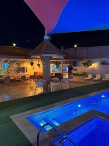 Al RamaにあるPrivate villa with pool in Deadsea Jordanの夜のテーブルとガゼボのあるプール +19枚の写真