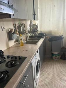 a kitchen with a sink and a washing machine at Mistral Bobigny in Bobigny