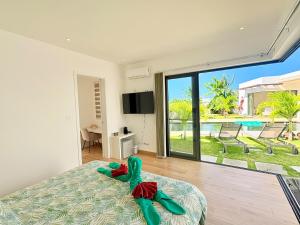 a bedroom with a bed and a view of a pool at Zolikaz in Grand-Baie
