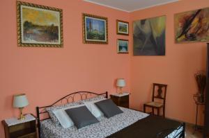 a bedroom with a bed and paintings on the wall at B&B Cambusa in Motteggiana