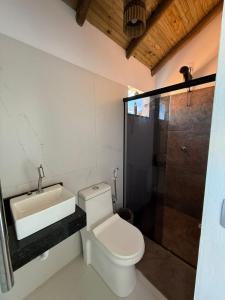 Un baño con inodoro, lavabo y ducha. en Vila Viver Caraíva, en Caraíva