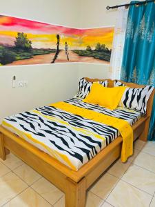 1 cama en una habitación con un cuadro en la pared en Résidence Yavanie, en Kribi