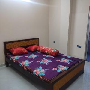 a bed with two red pillows on top of it at Best Eastern, Nikunja-2 in Dhaka