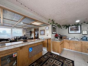 a kitchen with wooden cabinets and a counter top at Budget Inn Corcoran Near Tulare CA 43 in Corcoran