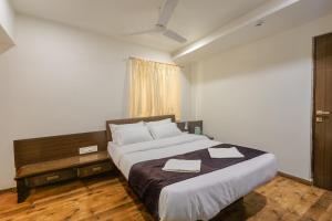 a bedroom with a large bed with two towels on it at HOTEL VINTAGE Inn in Vadodara