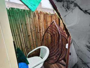 Una silla en una habitación con una valla de bambú. en Aircraft themed unique stay with pool, en Zirakpur
