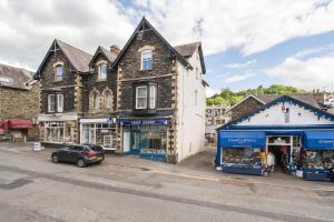 un edificio al costado de una calle con una tienda en Perfectly Located, Central Bowness Flat With Free Parking and Lake Views, en Windermere