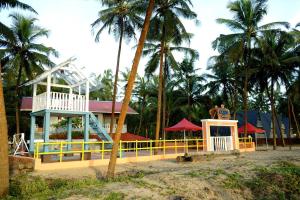 a man standing on top of a building with palm trees at Aqua Beach Retreat in Kottakkal