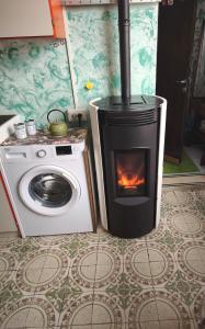 a kitchen with a stove and a washing machine at Ca' della Sfinge Colibrì a Civiasco in Varallo