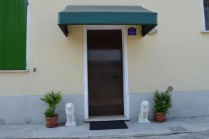 una porta per un edificio con un tendone verde di B&B Cambusa a Motteggiana