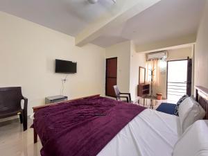 a bedroom with a large bed and a flat screen tv at The cozy Inn in Calangute